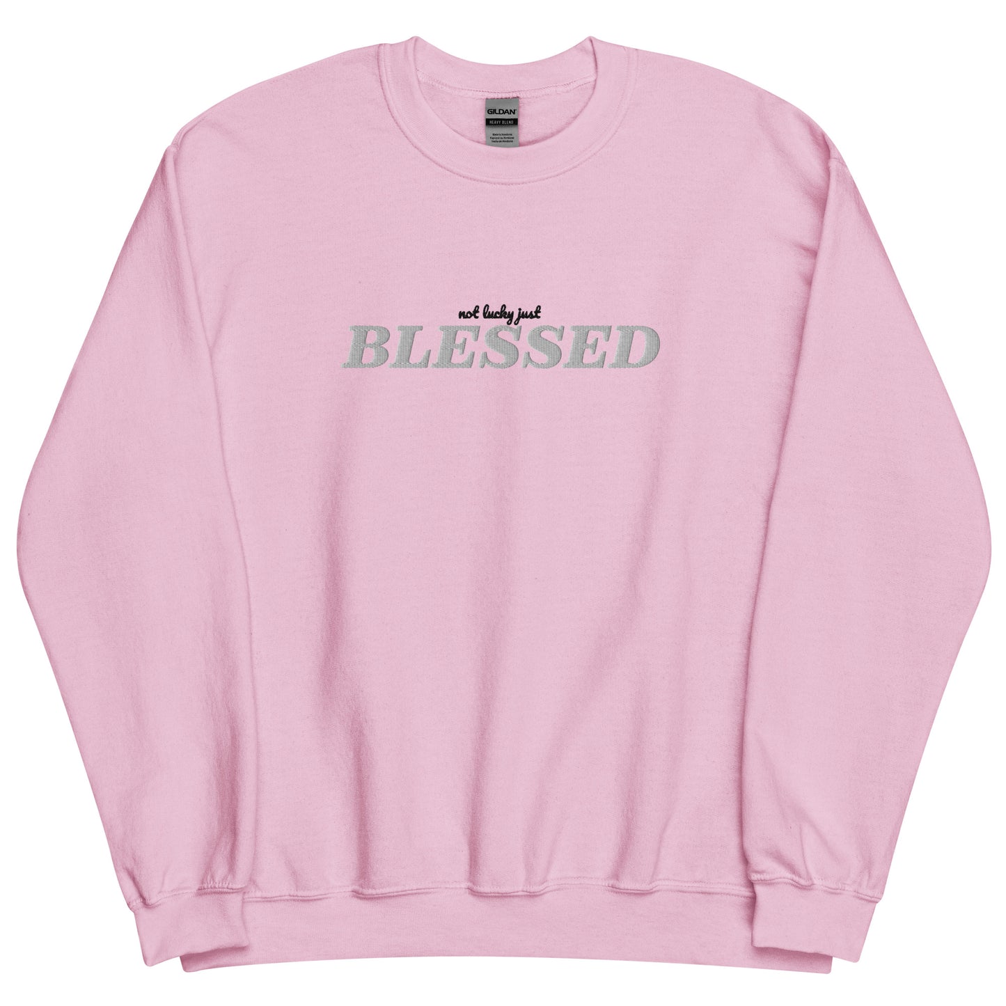 Licht roze sweater met geborduurde letters op de borst.